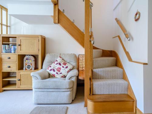 a living room with a chair and a staircase at 2 Bed in Instow 78256 in Instow