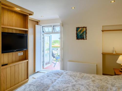 a bedroom with a bed and a sliding glass door at 2 Bed in Instow 78256 in Instow