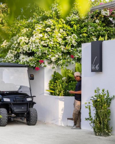 a man standing next to a wall with a jeep at Villa Mia Fulhadhoo in Fulhadhoo
