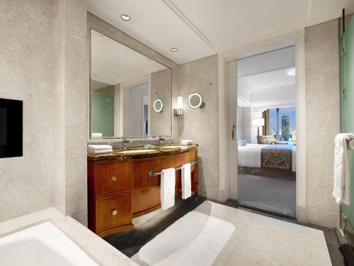 a bathroom with a sink and a large mirror at Shangri-La Jakarta in Jakarta