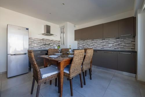 a kitchen with a wooden table and chairs and a refrigerator at Bright and Spacious Penthouse with Large Terrace in Msida