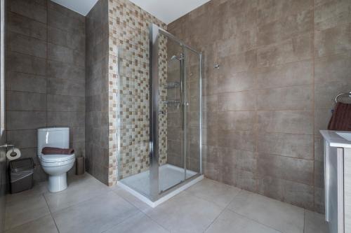 a bathroom with a toilet and a glass shower at Bright and Spacious Penthouse with Large Terrace in Msida
