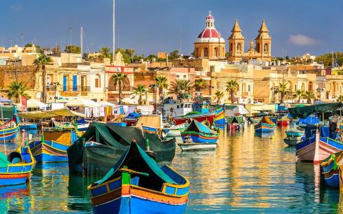a group of boats docked in a harbor with buildings at Bright and Spacious Penthouse with Large Terrace in Msida