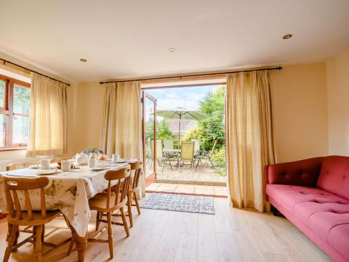 a living room with a table and a pink couch at 3 Bed in Bretforton 89477 in Bretforton