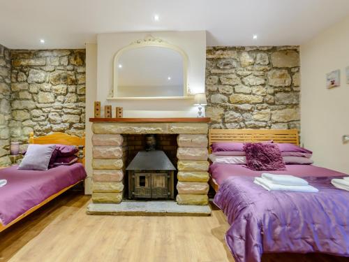 two beds in a room with a stone fireplace at 2 bed in Rothbury 74812 in Rothbury