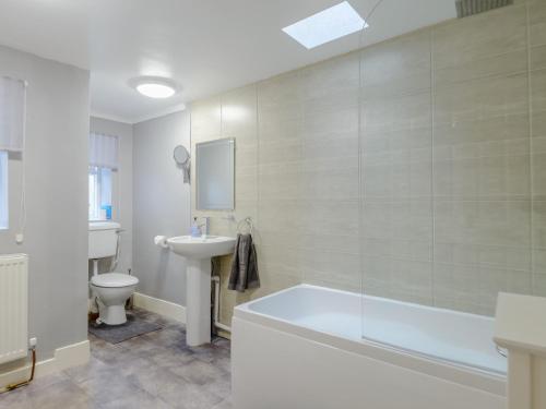 a bathroom with a tub and a sink and a toilet at 2 bed in Rothbury 74812 in Rothbury