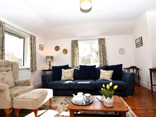 a living room with a blue couch and a table at 3 bed in Kirriemuir 82244 in Kirriemuir