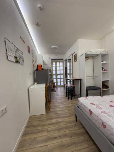 una camera da letto con un letto, una cucina e un tavolo di Loft Largo Gloria locazione turistica a Messina