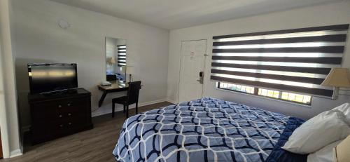 a bedroom with a bed and a desk and a television at Merida Inn & Suites in Saint Augustine