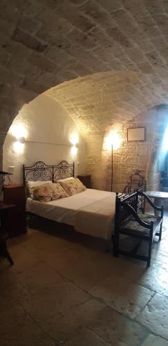 a bedroom with a bed in a stone wall at alaséu in Bitonto