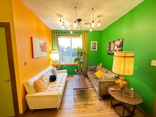 a living room with green walls and a couch at Hostel Detroit in Detroit