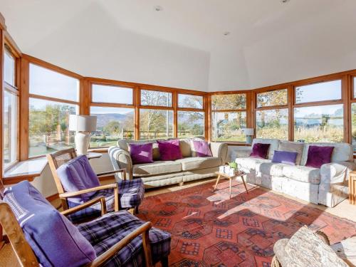 a living room with a couch and chairs and windows at 3 Bed in The Cairngorms 53150 in Dinnet