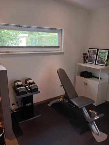 a room with a gym with a chair and a window at Gavi place to stay in Hamburg