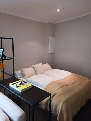 a bedroom with a bed and a table with a book at Gavi place to stay in Hamburg
