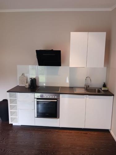 a white kitchen with a sink and a microwave at Gavi place to stay in Hamburg