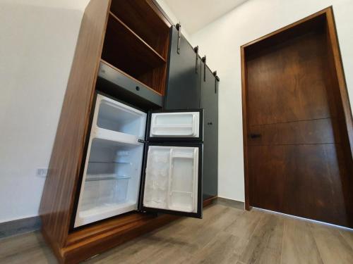 an empty refrigerator with its door open in a room at Hotel Camino del Bosque Atlixco in Atlixco