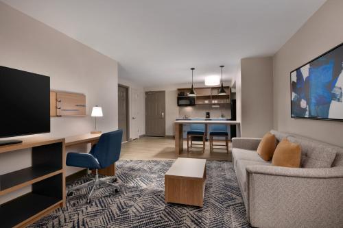 a living room with a couch and a tv at Candlewood Suites Wake Forest-Raleigh Area by IHG in Wake Forest