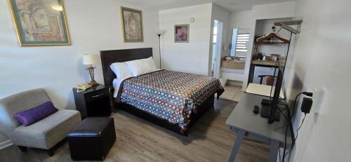 a bedroom with a bed and a chair in a room at Merida Inn & Suites in Saint Augustine