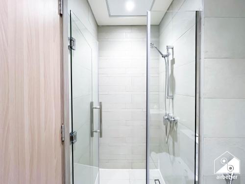 a shower with a glass door in a bathroom at Urban Charm Studio with Balcony in Azizi Riviera in Dubai