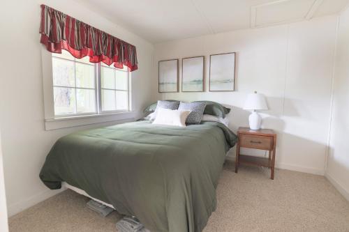 een slaapkamer met een bed en twee ramen bij Wilderness West Resort Cabin 6 in Colville