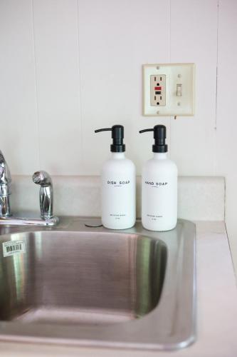 two bottles of soap sitting on top of a sink at Wilderness West Resort Cabin 6 in Colville