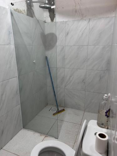 a bathroom with a shower with a toilet and a broom at Casa Pitombeira in Aracati