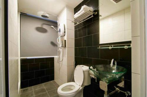 a bathroom with a toilet and a glass sink at I LUX I-Hotel Kuala Lumpur in Kuala Lumpur