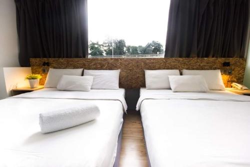 two twin beds in a room with a window at I LUX I-Hotel Kuala Lumpur in Kuala Lumpur