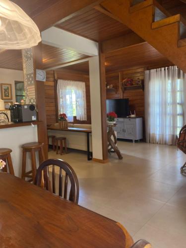 a dining room and living room with a table and chairs at Chalé Domingos Martins in Domingos Martins