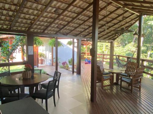 a dining room with tables and chairs on a deck at Chalé Domingos Martins in Domingos Martins