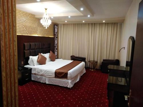 a hotel room with a bed and a chandelier at فندق السلطان ان Alsultan Inn Hotel in Jazan