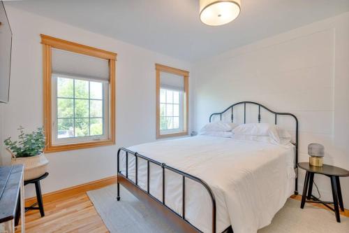 a white bedroom with a bed and two windows at The Laurel Leaf at Annes Windy Poplars in Cavendish