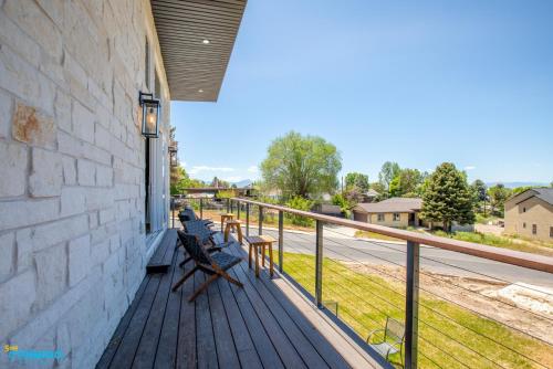 a porch with chairs and a railing on a building at Gathering Place Hot Tub Game rooms in Orem