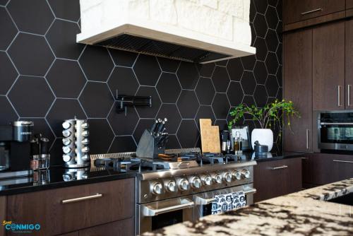 a kitchen with a stove and a black wall at Gathering Place Hot Tub Game rooms in Orem