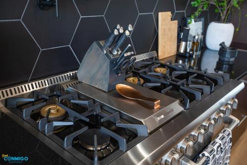 a kitchen stove top with a black counter top at Gathering Place Hot Tub Game rooms in Orem