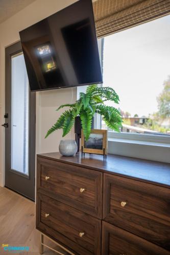 a wooden dresser with a plant on top of it at Gathering Place Hot Tub Game rooms in Orem