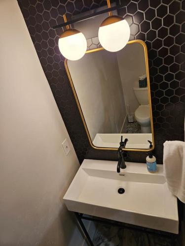 a bathroom with a sink and a mirror at Gathering Place Hot Tub Game rooms in Orem