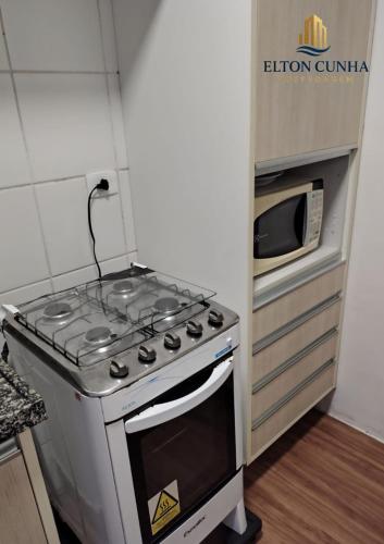 a kitchen with a stove and a microwave at NÉO 1 - 511 - Pajuçara - Inesquecível! in Maceió