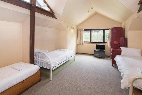 a attic room with two beds and a tv at Trastevere Farmhouse-Working Cattle Farm-Family Escape in Cowaramup