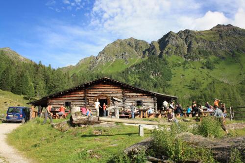 a group of people standing outside of a log cabin at Ferienhotel Gasthof zur Post in Untertauern