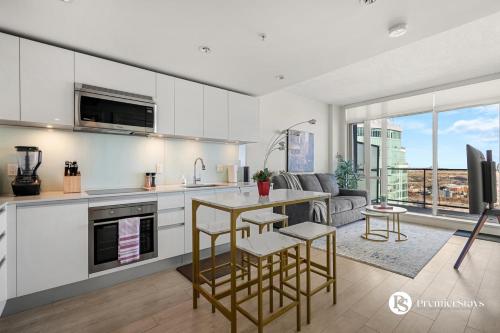 a kitchen and living room with a table and chairs at Executive Suite on the 31st Floor Queen Bed with Sofa Bed Free Parking BBQ in Calgary