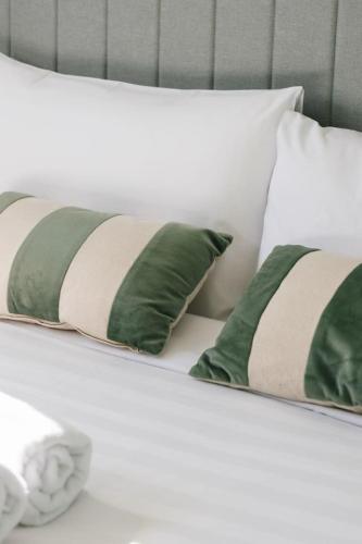 a bed with green and white pillows on it at Spacious 4BR Home Great Area close to everything in Ripley