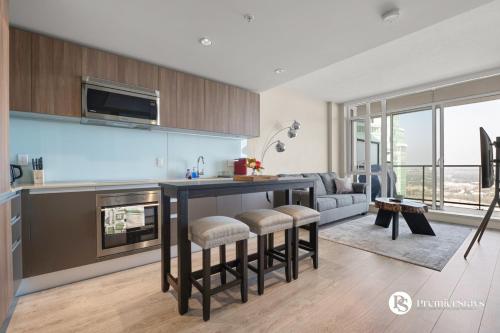 a kitchen with a table and some chairs in a room at 28th Floor High Rise Apartment Near Stampede Sleeps 4 with Free Secure Parking in Calgary