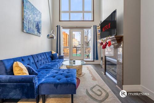 Una sala de estar con un sofá azul y un televisor. en Executive 3 Bedroom Penthouse in Downtown Calgary, en Calgary