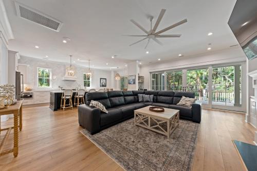 a living room with a black couch and a table at Stunning New Home with Private Pool in Seabrook Island