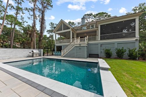 a home with a swimming pool in front of a house at Stunning New Home with Private Pool in Seabrook Island