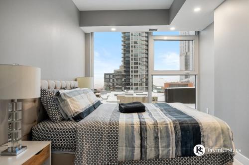 a bedroom with a bed and a large window at Central Downtown near Rogers Sleeps 6 with Two Queen Beds and Parking in Edmonton