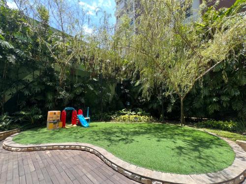 a small garden with a playground in the middle at Apartment Borneo Bay City - AH Property Indonesia in Balikpapan