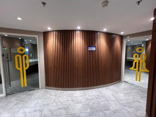 a lobby with a wooden wall with yellow handles at Apartment Borneo Bay City - AH Property Indonesia in Balikpapan