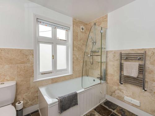 a bathroom with a tub and a shower and a toilet at 2 Bed in Eastbourne EHC06 in Eastbourne